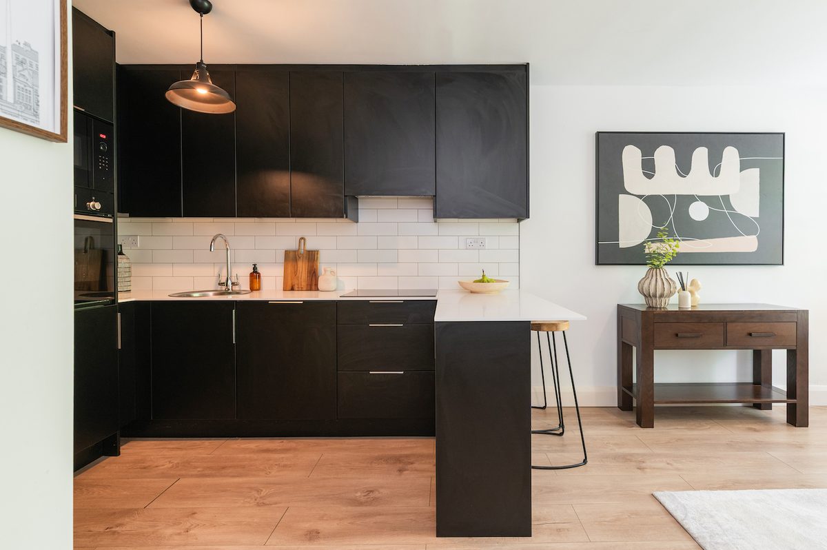 Fitted matte-black kitchen with pendant lighting and breakfast bar in EirStay Islandbridge serviced apartment Dublin 8