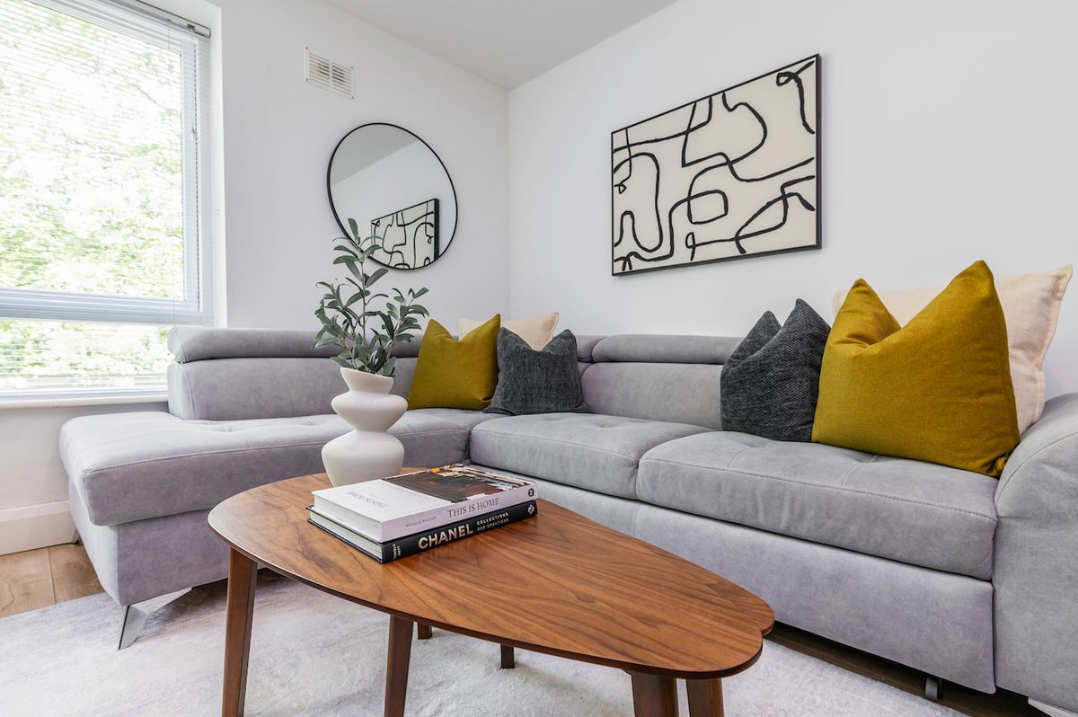 Grey corner sofa and oval coffee table beneath abstract art in EirStay Islandbridge corporate accommodation Dublin 8